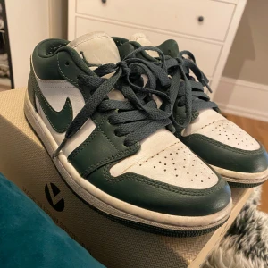 Nike Air Jordan 1 Low gröna/vita - Nike Air Jordan 1 Low sneakers i grönt och vitt skinn på sidorna och Air Jordan-logga broderad på hälen. 