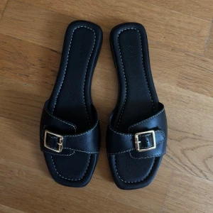 Svarta sandaler i läder från NA-KD - Jättefina Oanvända tofflor från NA-KD. Äkta läder.  Nypris 699kr  Skickar i lådan som de kom i  Kolla mina andra annonser, säljer massa mer💛