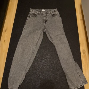 Grå jeans från Grunt, storlek 26 - Säljer ett par grå tvättade jeans från Grunt i storlek 26. Klassisk femficksmodell med raka ben och normal passform. Jeansen har en snygg stentvättad look och är tillverkade i jeanstyg av bomull.