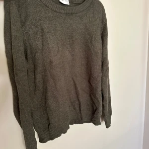 Beige stickad tröja från Vila - En enkel och stilren beige stickad tröja från Vila i storlek XL. Tröjan har rund halsringning, ribbade muddar och lång ärm. Perfekt för lager-på-lager och passar till allt i garderoben.