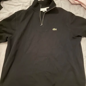 Svart half zip tröja från Lacoste - Svart half zipper tröja från Lacoste, passar med mycket och ÄKTA.