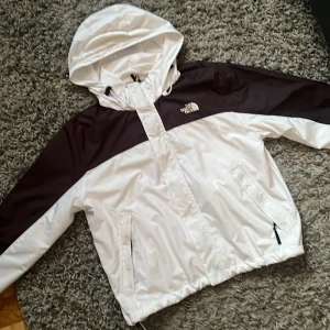 Vit och svart vindjacka från The North Face - Hjälper morsan att sälja en vit och svart vindjacka från The North Face i storlek Medium, jackan är i väldigt fint skick och Hon vill sälja jackan då den är för liten, men passar folk som har Medium