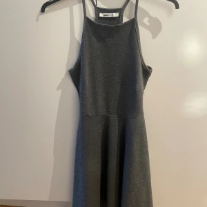 Grå ärmlös klänning Gina Tricot XS - Mörkgrå klänning från Gina Tricot i storlek XS. Klänningen har lätt utställd kjol och är tillverkad i mjukt, stretchigt material som ger en bekväm passform. Lite slapp i sömmen på ett ställe. 