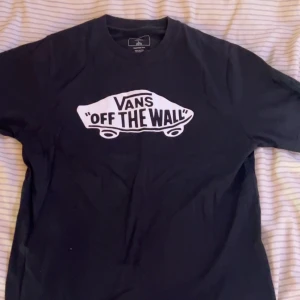 Svart Vans t-shirt  - Svart t-shirt från Vans med det klassiska 'Off The Wall'-trycket i vitt framtill. Modellen är kortärmad och har en rund halsringning. Tillverkad i 100% bomull för en skön och avslappnad känsla. Har aldrig använt och vill inte ha kvar den för det kommer inte till användning. 