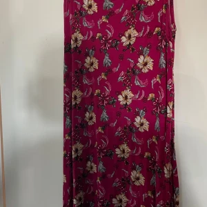 Blommig rosa klänning från Indiska - Supersöt ärmlös klänning från Indiska i en härlig rosa nyans med blommigt mönster i beige, gult och grått. Tillverkad i mjuk viskos som känns skön mot huden. Perfekt för dig som gillar färg och mönster! Den är i storlek S.