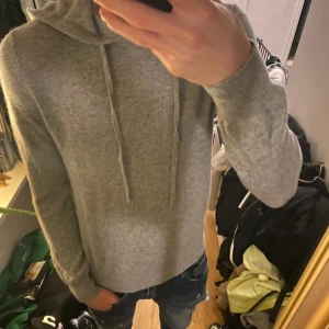Grå kashmir hoodie från ROVOIR - Grå kashmir hoodie i okej sick, det är lagat på båda armbågarna som man kan se på bild 3, men det är knappt något man märker från långt håll. Priset är ej hugget i sten och kan diskuteras vid snabb affär. Storlek: S. Köpt för 900 kr