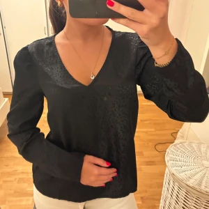 Svart blus med leopardmönster - Säljer en svart blus från Vero Moda i storlek S. Blusen har leopardmönster, v-ringning och långa ärmar. Använd nån gång