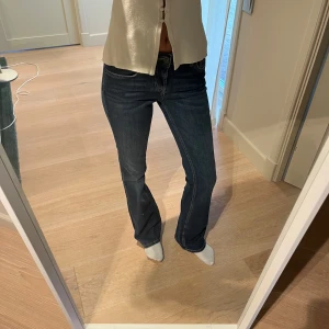Mörkblå bootcut jeans - Snygga mörkblå jeans med bootcut passform och klassisk femficksdesign. Jeansen har låg midja och är tillverkade i ett stretchigt denimtyg som sitter skönt. Perfekta för dig som gillar en tidlös och trendig look.