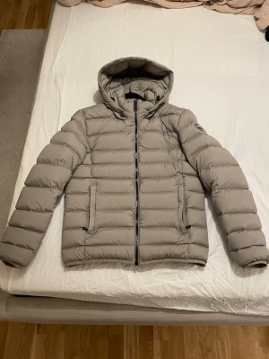 Colmar Jacka Herr - Säljer denna extremt snygga Colmar Jacka i beige färg.   Jackan är köpt i höstas 2025 och är i nyskick dvs inte en enda fläck, hål eller dylikt - den är endast använd ett handfull gånger.  Storlek - 48 S/M Herr  För referens är jag 184cm/68kg  Skick - 10/10   Jackan är självklart äkta.  Nypris på jackan är 3000kr.  Mitt pris 2000kr.                                                           Tveka inte på att höra er om ni undrar något eller vill ha fler bilder!