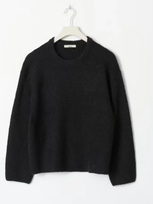 Svart stickad tröja från Gina tricot  - En stilren svart stickad tröja från Gina tricot. Tröjan har en rak passform och är gjord i ett mjukt, värmande material som passar perfekt till kyligare dagar. Enkel att matcha med olika outfits.