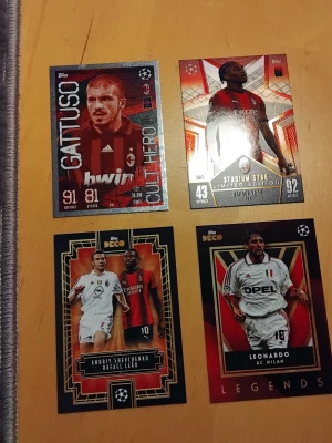 AC Milan fotbollssamlarkort 4-pack - Fyra samlarkort med AC Milan-tema från Topps, inklusive spelare som Gattuso, Rafael Leão, Shevchenko och Leonardo. Korten har olika designer, vissa med holografiska detaljer och klubbens logga. Perfekt för dig som gillar fotboll och samlar på sportkort. Plastficka ingår.
