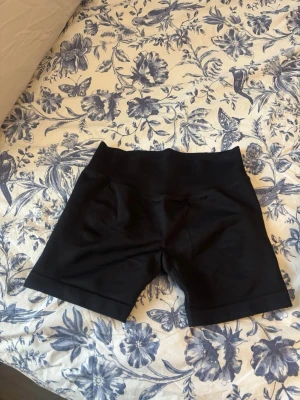 Svarta seamless shorts från Relode - Snygga svarta seamless träningsshorts från Relode med scrunch-detalj bak (likt dfyne). Stretchigt material som sitter skönt och formar sig efter kroppen, perfekta för gymmet eller löpning. Helt nya endast provade, skickas med orginalförpackning:)) Ordinarie pris 579kr