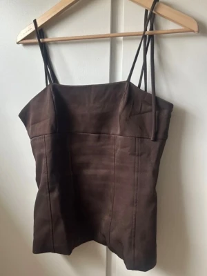 Brun topp med knytband - Snygg brun topp med tunna axelband som knyts i rosetter