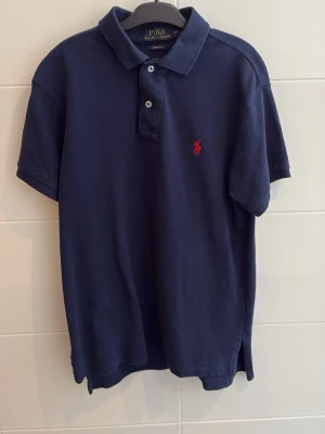 Piké Polo Ralph Lauren - Snygg piké från Ralph Lauren marinblå i storlek S och bra skick. Passar mig bra är 175cm och väger 55kg om ni har frågor bara att höra av er.