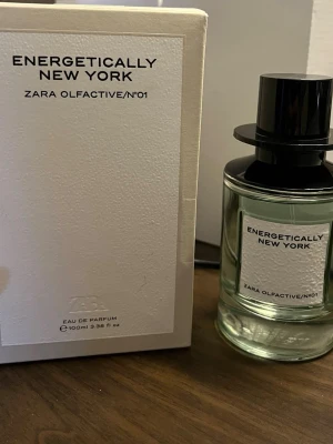 Energetically New York parfym Zara - Energetically New York från Zara. Flaskan har en stilren design och är sparsamt använd, det är ca 90 ml kvar. Parfymen har förvarats mörkt och svalt för att bevara doften på bästa sätt.                                               Det här är en unik och modern doft för dig som vill sticka ut. Den är ren och fräsch, men har samtidigt en fin värme från trä och kryddor. Perfekt om du vill undvika det söta och sliskiga, men ändå vill ha en doft med karaktär och djup.