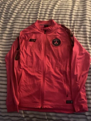 Rosa Nike PSG Dri-Fit träningsjacka - PSG tröja från Nike, det finns några defekter men det är bara fläckar och går och lösa genom att lägga diskmedel på och lägga den i tvätten på 40-60 grader