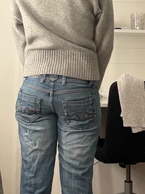 Jeans med snygga fickor  - Säljer ett par blålågmidjasd bootcut jeans med snygga fickor .