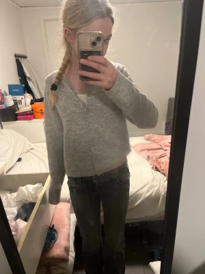 Grå bootcut jeans med låg midja - Säljer ett par gråa bootcut jeans med låg midja. Jeansen har klassisk femficksdesign och stängs med knapp och dragkedja. Snygg tvättad look och passar perfekt till en avslappnad stil. Storlek 146