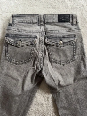 Grå bootcut jeans från Gina tricot  - Snygga grå jeans från Gina tricot med bootcut passform och fickor baktill 