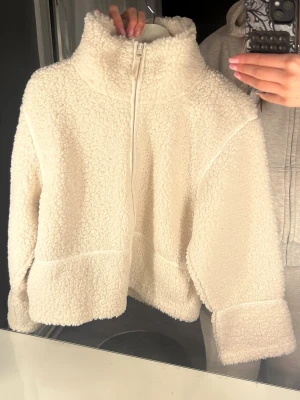 Vit teddyjacka från Gina Tricot - Säljer denna super fina teddyjacka från GinaTricot, på bild 3 ser ni att inga smink fläckar finns! Använt max 2 ggr