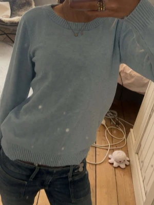 Ljusblå stickad tröja från vila - Trendig Mysig ljusblå stickad tröja med rund halsringning och ribbade muddar vid ärmslut och nederkant. Perfekt att matcha med jeans för en avslappnad look. Enkel och stilren design utan synligt märke.
