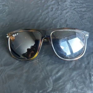 Ray-Ban Wayfarer solglasögon svart - Snygga Ray-Ban Wayfarer solglasögon org pris 1899kr med svart och transparent brun plastbåge. Klassisk fyrkantig form och polariserade mörka glas. Pris kan diskuteras