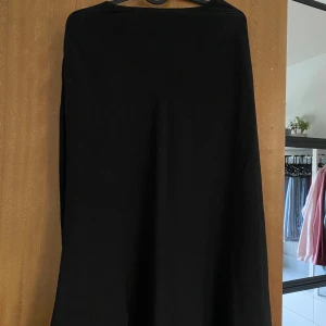 Svart långkjol från Amisu - En stilren svart långkjol från Amisu i klassisk A-linjeform. Kjolen har en enkel design utan mönster och stängs med dragkedja i sidan. Perfekt för dig som gillar minimalistiska och tidlösa plagg.