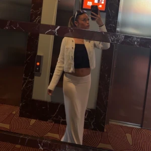 Beige långkjol i stretchigt material - Säljer en beige långkjol med tight passform och hög midja. Kjolen är enkel och stilren, gjord i ett stretchigt och mjukt material som sitter snyggt längs kroppen. Perfekt för dig som gillar en clean och trendig look.