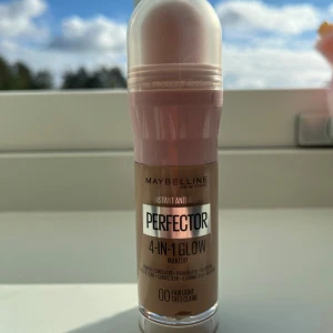 Maybelline Perfector 4-in-1 Glow Fair Light - Säljer en helt ny, oöppnad Maybelline Instant Anti-Age Perfector 4-in-1 Glow i nyansen 00 Fair Light. Multifunktionell produkt som funkar som primer, concealer, highlighter och BB cream. Kommer i en praktisk flaska med rosa och transparent lock, perfekt för en naturlig glow.