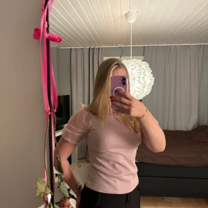 Rosa topp med puffärmar från Vila - Supersöt ljusrosa topp från Vila med korta puffärmar i transparent material. Toppen har rund halsringning och en figurnära passform. Perfekt för dig som vill ha en feminin och trendig look med extra volym på ärmarna. Använd några gånger men i fortsatt bra skick!