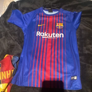 FC Barcelona matchtröja Nike 2017 - Säljer en officiell FC Barcelona matchtröja från Nike, säsongen 2017. Tröjan är blå med röda vertikala ränder, har klubbmärke och Rakuten-logga på bröstet samt Unicef-tryck på ryggen. Kortärmad modell i lätt polyester, perfekt för dig som älskar Barca.