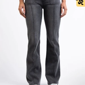 Gråa bootcut jeans med fickor - Snygga grå jeans med markerade sömmar och stora fyrkantiga fickor framtill. Modellen har bootcut-ben och hög midja för en trendig siluett. Jeansen är tillverkade i klassiskt denimtyg och passar perfekt till sneakers eller boots.