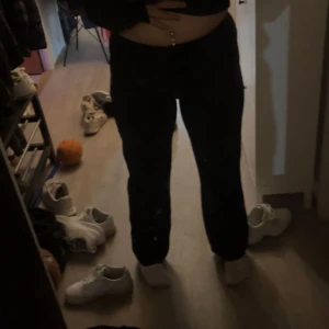 Svarta vida byxor med hög midja - Säljer ett par svarta kostymbyxor med hög midja och vid passform. Kostymbyxorna har en enkel och stilren look, perfekta att matcha med crop tops eller hoodies. Materialet ser ut att vara mjukt och bekvämt, vilket gör dem sköna att bära hela dagen.