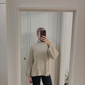 Beige ribbad polotröja med slits - Säljer en beige ribbstickad polotröja med hög krage och slitsar i sidorna.