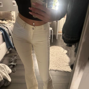 Vita bootcut byxor från Madlady - Säljer ett par vita bootcut-byxor från Madlady i storlek EU34/Tall. Byxorna är högmidjade med klassisk femficksdesign och har en snygg, figurnära passform upptill som går ut i bootcut nertill. Perfekta för dig som gillar stilrena och trendiga byxor. Näst intill oanvända. Jag är 176 lång🤍
