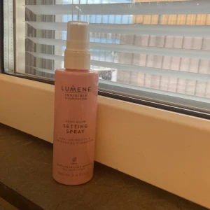 Lumene Dewy Glow Setting Spray 100ml - Lumene Invisible Illumination Dewy Glow Setting Spray i en rosa plastflaska med spray . Ger lyster och återfuktar huden, perfekt för att fixera sminket. Passar alla hudtyper och innehåller 100 ml. Vegansk formula och snygg design. Billigt pris, då ny kostar ca 150kr och den är nästan helt oanvänd vill inte behöva slänga den. Plast kvar på locket