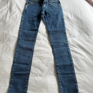 Jeans från Replay - Säljer ett par blå super skinny jeans från Replay. Jeansen har klassisk femficksdesign, normalhög midja och är tillverkade i stretchigt denim för en tajt passform. 10A, 142cm