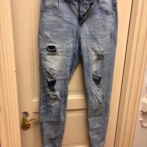 Ljusblå skinny jeans Shein - Säljer ett par ljusblå skinny jeans med flera slitningar och hål på benen. Vet ej storleken men passar som en storlek S. Stretchiga och sköna!