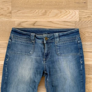 Lågmidjade utsvängda jeans - Jeans från marks & Spencer’s! Lappen är i två så svårt att se vad det står! Det står strlk 12 men skulle säga att dom är som en M! Midja:40cm innerben:71cm
