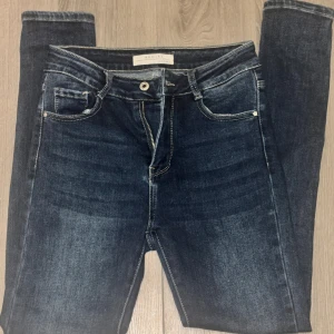 Mörkblå skinny jeans S - Snygga mörkblå skinny jeans från Redial med klassisk femficksdesign och kontrastsömmar. Jeansen har dragkedja och knapp framtill, samt är tillverkade i en stretchig bomullsblandning för en tight och bekväm passform.