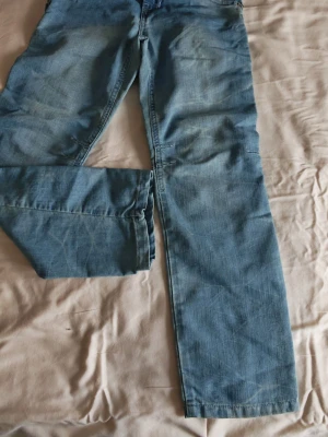 Barn jeans strl.134 fran Name It - Säljer ett par ljusblå barn jeans från Name It, str.134. modell Thomas Kids Baggy DNM Pant. Jeansen har klassisk dragkedja och knapp framtill, samt skön passform med lite lösare ben. Lite små i midija. 