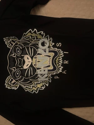 Äkta Svart sweatshirt från Kenzo med tiger - Svart sweatshirt från Kenzo i storlek S med ikonisk broderad tiger och Kenzo Paris-logga på bröstet. 