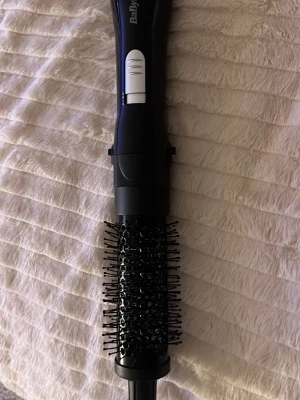 BaByliss svart varmluftsborste - Säljer en svart varmluftsborste från BaByliss med rund borste och täta borststrån i plast. Handtaget är ergonomiskt och har olika inställningar. Perfekt för att styla och ge volym till håret. Elektrisk med sladd.