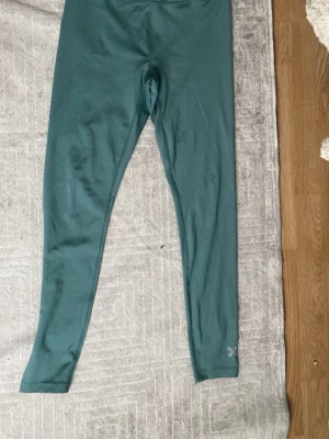 Ingen sko på bild - Bilderna visar ett par gröna tights eller leggings, inte skor. Kan ej ge skobeskrivning eller taxonomier relaterade till skor.
