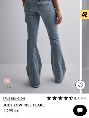 True Religion Joey Low Rise Flare Jeans - Säljer ett par ikoniska True Religion Joey low rise jeans i ljusblå tvätt. De har låg midja, utsvängda ben och klassiska fickdetaljer med stora knappar bak. Jeansen är i mjukt denim och har den typiska hästsko-sömmen på bakfickorna. De är i modellen Joey och är low rise flare. De är i W26 och är hela och fina. Är lite nötta längst ner, se bild, men absolut inget man tänker på. Bara höra av dig vid frågor eller fler bilder. Pris kan diskuteras💕