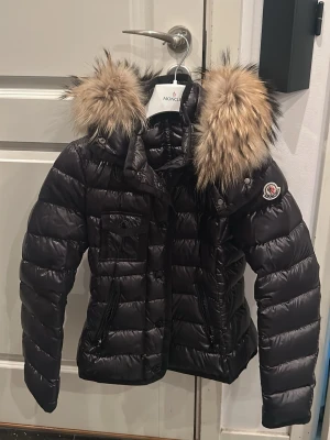 Moncler  jacka  - En äkta moncler jacka med avtagsbar luva, jackan är i fint skick. Alla tillbehör följer med, så som kvitto, dust bag. Köpt i Italien i butik. Skriv privat om du har frågor, storlek xs/xxs 