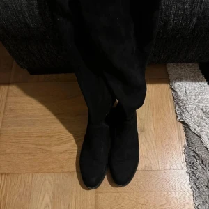 Svarta boots - Snygga svarta stövlar i svart med rund tå och platt sula. Stövlarna går upp över knäet och har dragkedja på insidan för enkel påtagning. Använd ca 2-3 gånger (säljer pågrund av de är för stora 💗