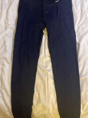 Mörkblå ribbade leggings från Aim'n - Säljer ett par mörkblå ribbade leggings från Aim'n. De har hög midja och är tillverkade i ett stretchigt material som sitter tight. Perfekta för träning eller chill. Klassisk Aim'n-logga i metall framtill på linningen.