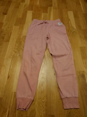 Rosa mjukisbyxor  - Rosa mjukisbyxor från Andy. Storlek S och normal i storlek. Liten fläck på ena benet som inte går bort (se bild). Väl använda och lite noppriga i tyget men perfekta att ha som "slit och släng" byxor om man ska ut med hunden eller måla till exempel 