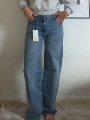 Zara wide leg jeans - Säljer ett par ljusblå jeans från Zara . Klassisk femficksmodell med knapp och dragkedja framtill. Jeansen har en avslappnad och trendig siluett som passar perfekt till sneakers eller boots.